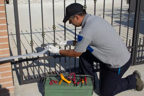 An electrician working on a metal gate